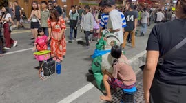 A two year old girl is scared of a funny dancing frog on the street in Pattaya, Thailand.