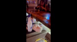 Woman eats noodles from purse at bar in Marysville, California, USA