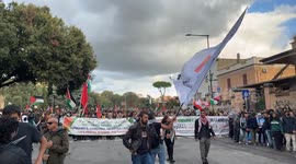 Pro-Palestine protesters march as one of the demonstrators waves the flag of the Palestinian Youth in Italy during the pro-Palestine rally in Rome.