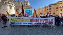 Protesters hold a banner with the slogan 'let's form a different world, workers and students united against precariousness' while waving flags of grassroots unions and the Palestinian flag during the protest of precarious teachers organized by the movemen