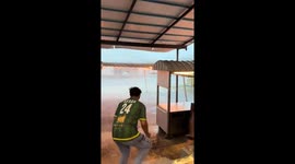 Campers hold tent being battered by rain storm