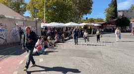 People coming and going in the entrance square of the Porta Portese market on a warm Sunday in October in Rome.