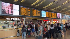 People at Rome's Termini station wait to catch their train as timetables show train cancellations and major delays amid a 24-hour strike called by some independent unions.