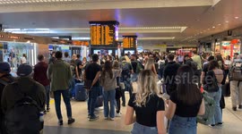 People at Rome's Termini station wait to catch their train as timetables show train cancellations and major delays amid a 24-hour strike called by some independent unions.