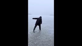 Man slips and falls on frozen lake in Heilongjiang, China
