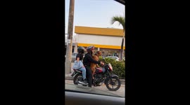 Dog rides motorcycle in sunglasses and sap in Guayaquil, Ecuador