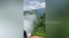 Adventure-seekers chill on hammocks above waterfall