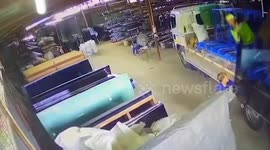 Large glass sheet shatters while workers carry it in warehouse
