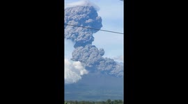 Pupils watch from school as Mount Kanlaon erupts with ash clouds in the Philippines