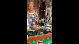 Chef cooks seafood on flame-stoking wok at street-side stall