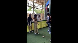 Giraffe head butts girl playing crazy golf