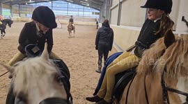 Girls attempt to swap ponies without touching the ground