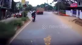 Motorcycle rider calmly saves boy from being run over by truck