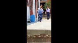 Student trips while carrying a gallon of water in Lampung, Indonesia