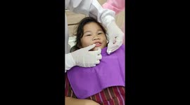 Ticklish girl laughs as dentist pulls out her tooth