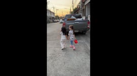 Two adorable kids go for a walk to the park at sunset hand in hand.