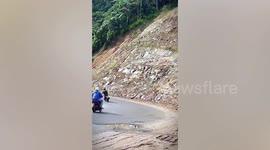 Landslide crashes onto road in front of motorcycle rider