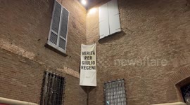 A banner with the slogan ‘truth for Giulio Regeni’ hung at night on the wall of an ancient building in the center of Bologna.