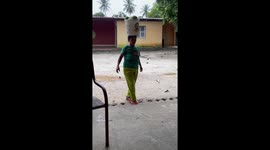 Woman balancing a pail of fruit falls in Pindoretama Ceará, Brazil
