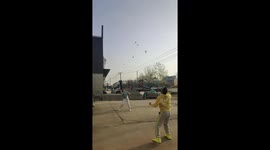 Two men play badminton with six shuttlecocks in Henan Province, China