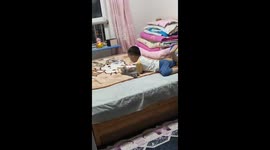 Boy reads a picture book with a kitten in Inner Mongolia, China