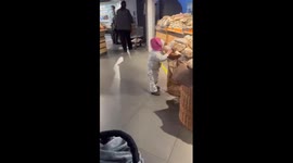 Child tries to bite food in Ukrainian store