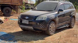 He drove his Chevy to the Paddy but the Paddy was dry, a Thai farmer uses his Chevrolet car to thrash rice at Phetchabun.