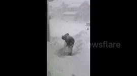 US: Man tries to clean pathway during heavy snowfall