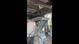 Mechanics remove monitor lizard stuck under car