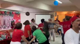 Office colleagues play balloon keepy uppy at Christmas party