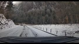 White car overtakes and crashes on slippery snowy road in Sichuan, China