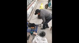Old man spills popcorn while using traditional machine in Henan, China