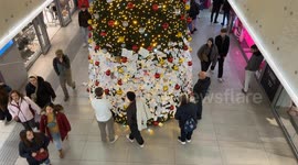 Travelers read wish cards that were hung by travelers on the decorated Christmas tree installed inside Termini Station during the Christmas season in Rome.
