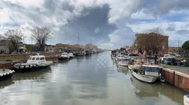 Boats anchored along the canal port on a cloudy December day in Fiumicino