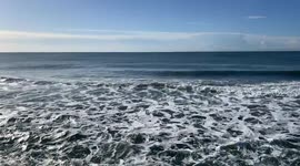 A stretch of sea at Lido di Ostia with gentle waves and foam on a clear December day in Rome.