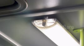 Detail of an internal lighting lamp of an old polluting bus, not completely closed and with some electrical wires exposed, which vibrates during the journey in Rome.