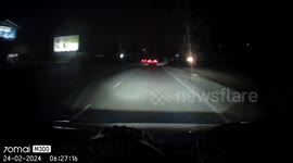 Close Call: Red Car's Lane Switching Nearly Endangers Biker and Oncoming Vehicle