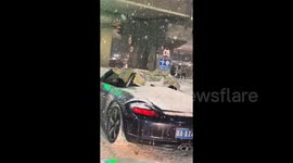 Porsche driver uses makeshift plastic sheet to shield themselves from snow in China