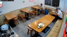 Restaurant owner rescues diner choking on food while young man gazes at his phone