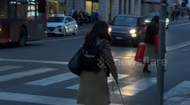 The journey of a blind woman who helps herself with her cane to avoid obstacles in Rome.