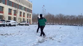 Two guys slip and laugh in the snow in Xinjiang, China