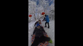 Friends ride inflatable ring through snowy slide in Jilin, China