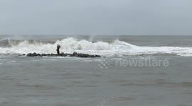 The statue of Neptune and its cliff surrounded by very rough seas on the Lido di Ostia in Rome.