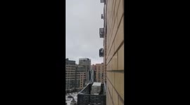 Young man hangs on air conditioner fence in Tyumen, Russia