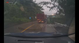 Dashcam captures collision between two trucks on wet road in Sichuan, China