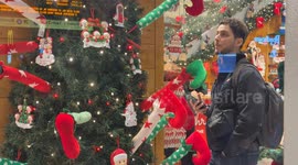The window of a shop selling Christmas gadgets with some people inside looking at the items for sale during the Christmas period in Rome.