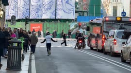 A man jumps rope while running and wears a T-shirt that says ‘SOS Cuba’ at the end of Via del Corso in Rome.