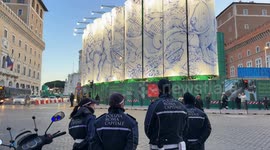 Agents of the Rome Capital Police guard the intersection of Piazza Venezia and in the background the installation of the mural “The Constellations of Rome” by the artist Pietro Ruffo, on the silos of the construction site of the Metro C stop in Rome.
