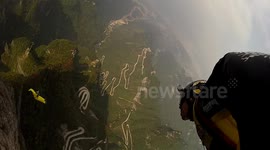 Crazy wingsuit proximity  BASE jump flying past cable cars in China
