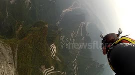 Crazy BASE jump wingsuit proximity flying past cable cars in China